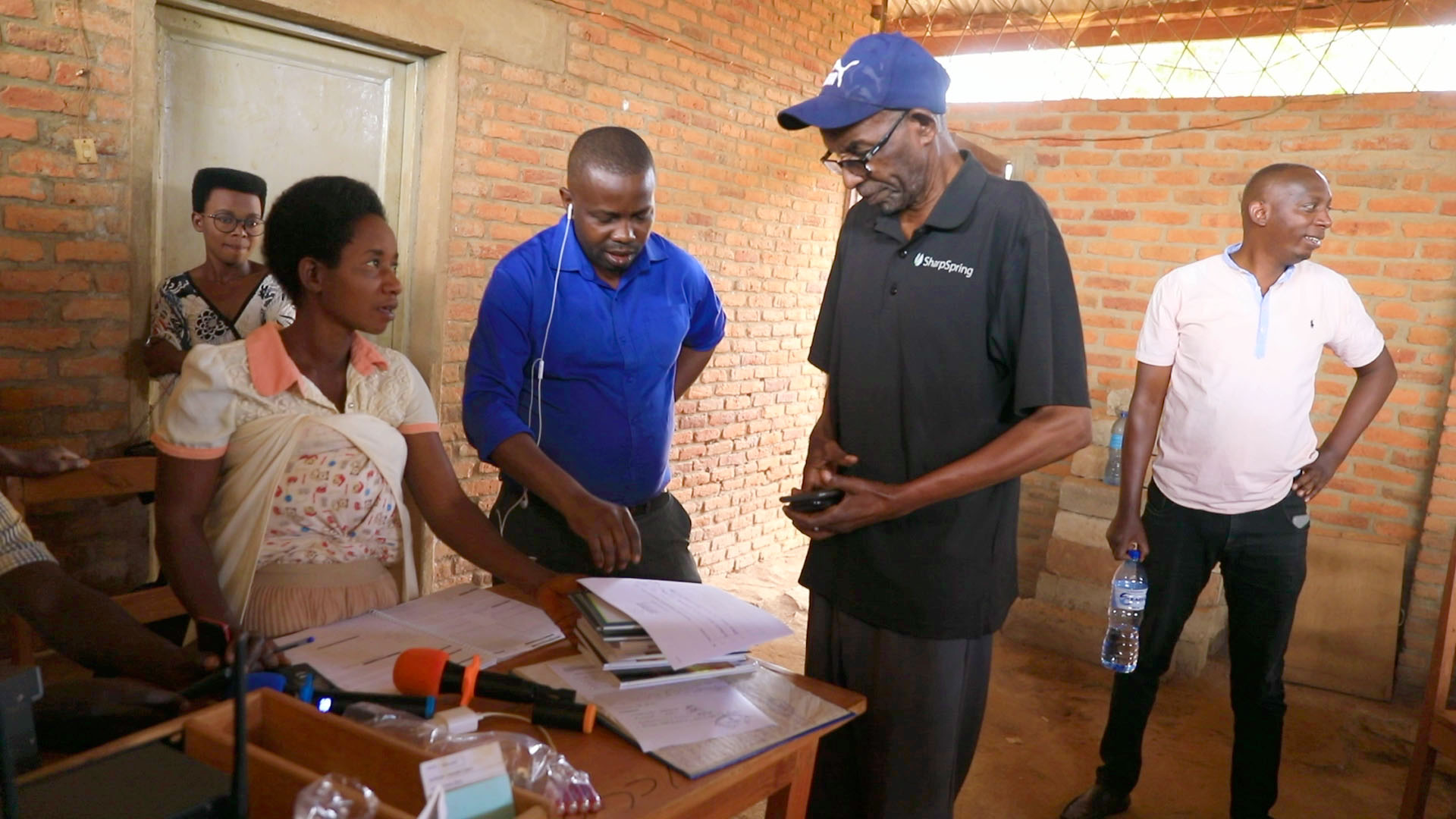 Five people standing around a desk with papers